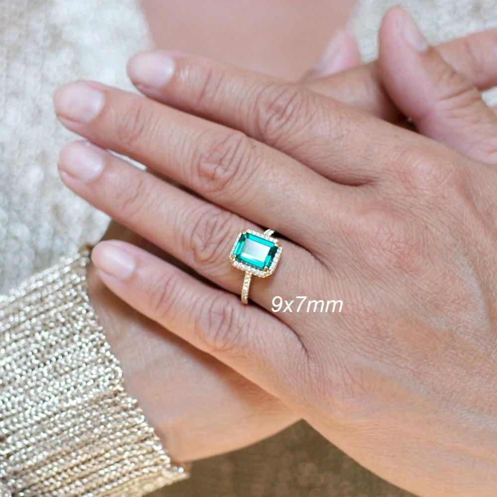 Emerald Cut Emerald With Diamond Halo Engagement Ring In Yellow Gold Cathedral Setting On a Hand