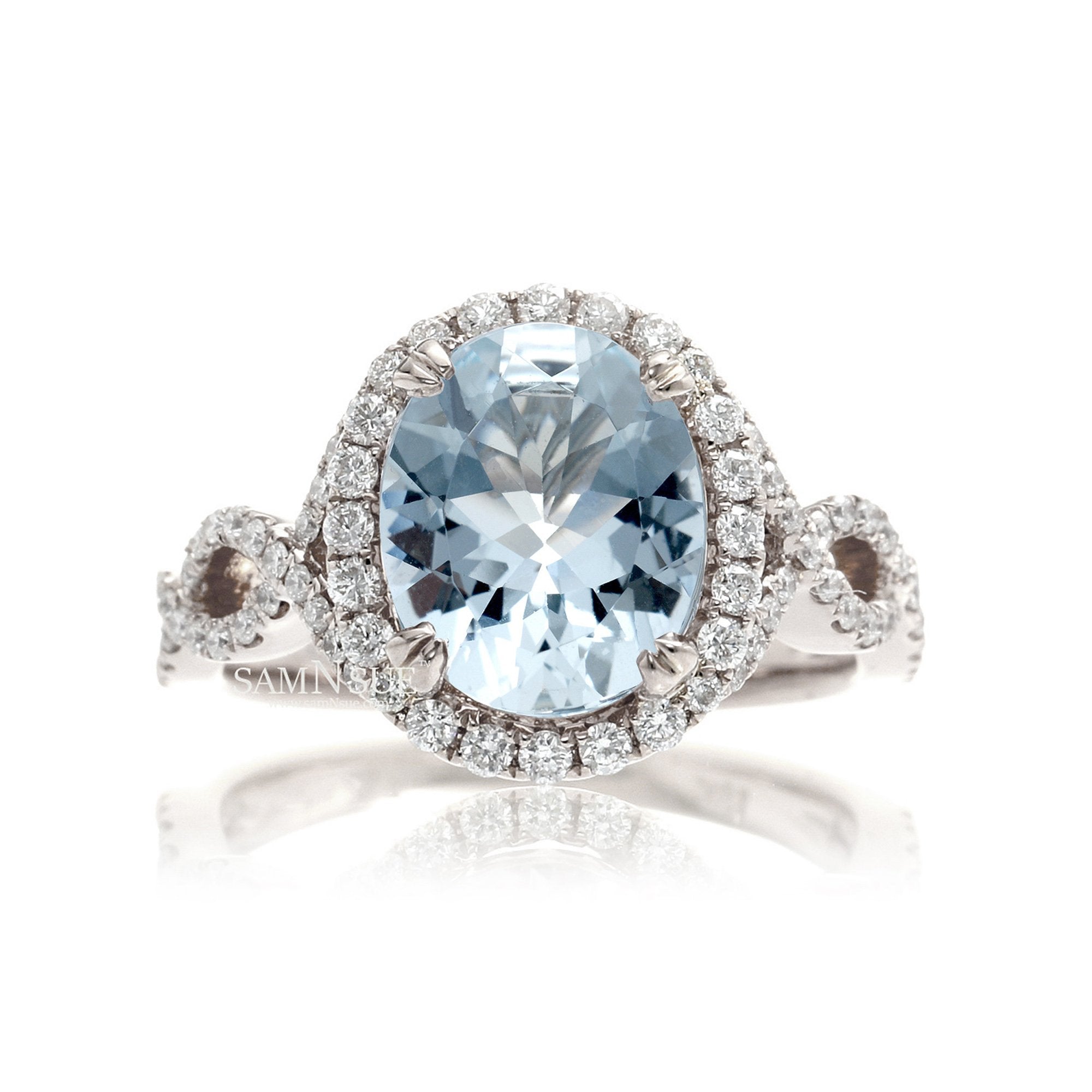 Oval cut aquamarine with diamond halo and twisted band white gold