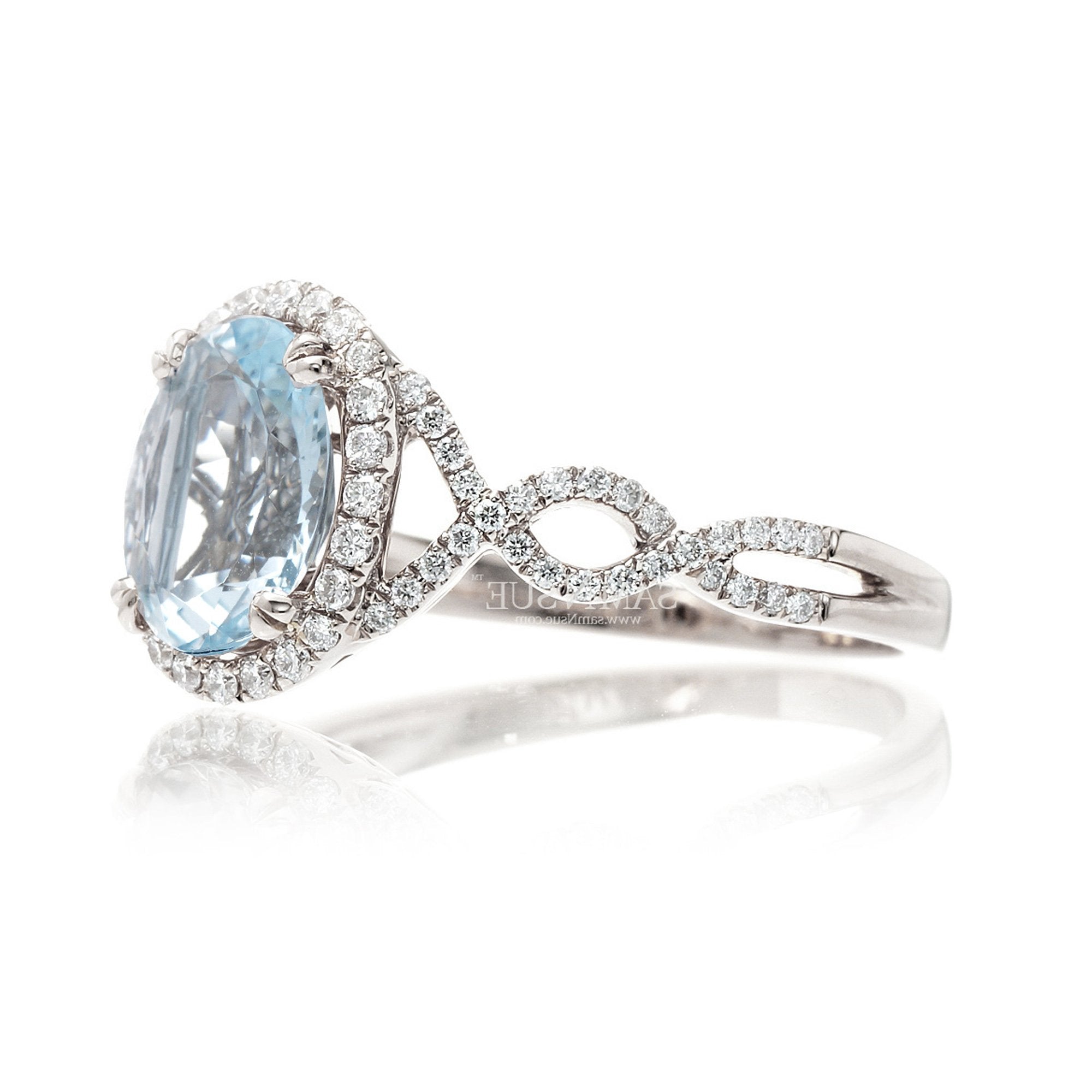 Oval cut aquamarine with diamond halo and twisted band white gold