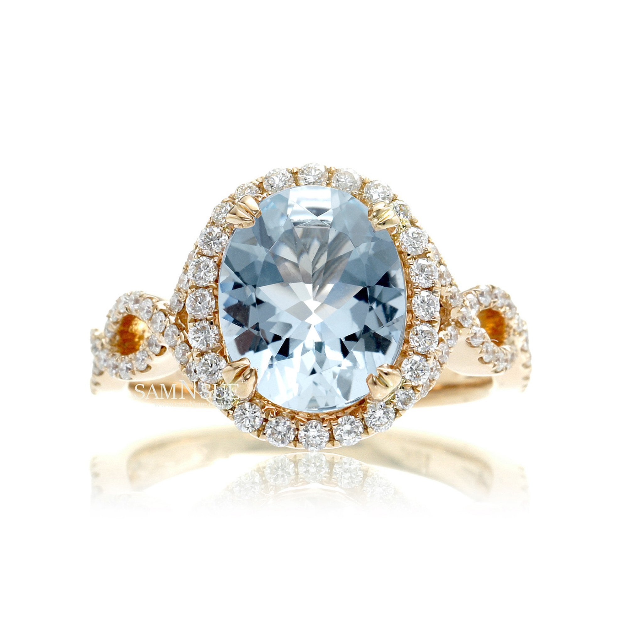 Oval cut aquamarine with diamond halo and twisted band yellow gold