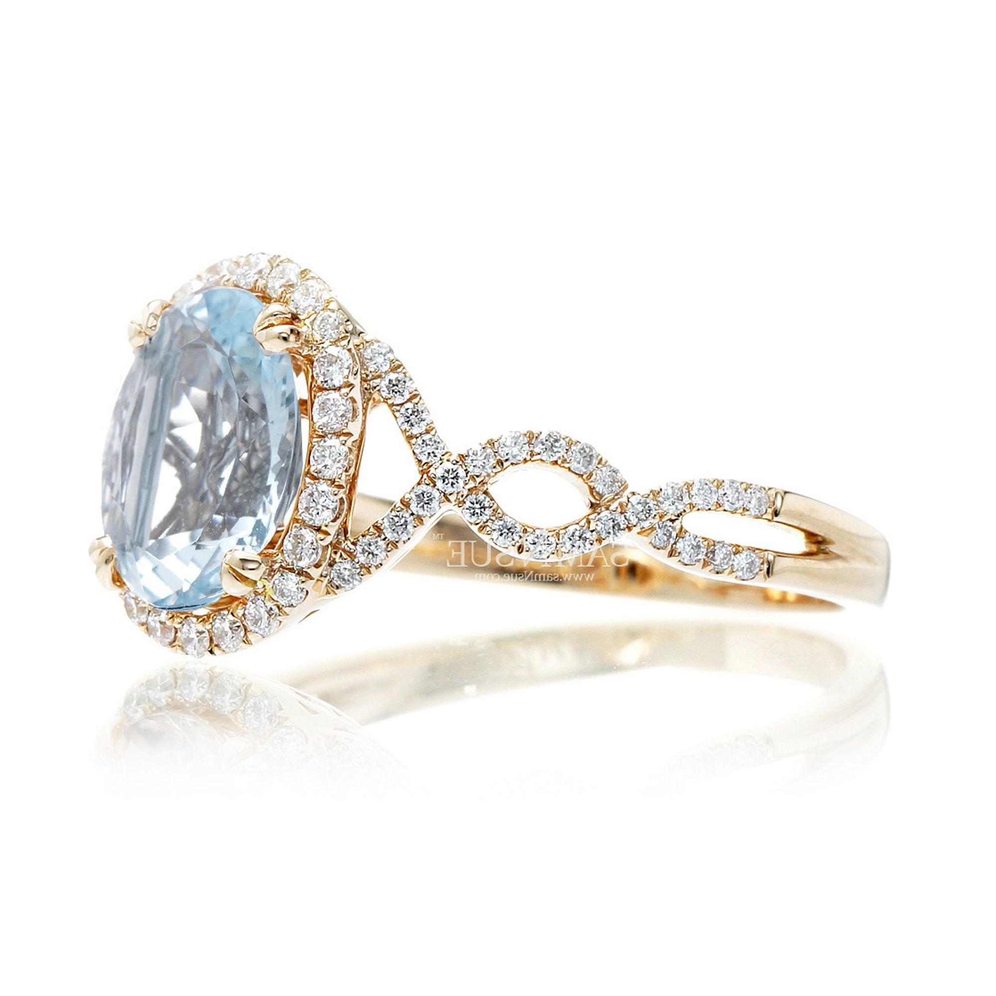 Oval cut aquamarine with diamond halo and twisted band yellow gold